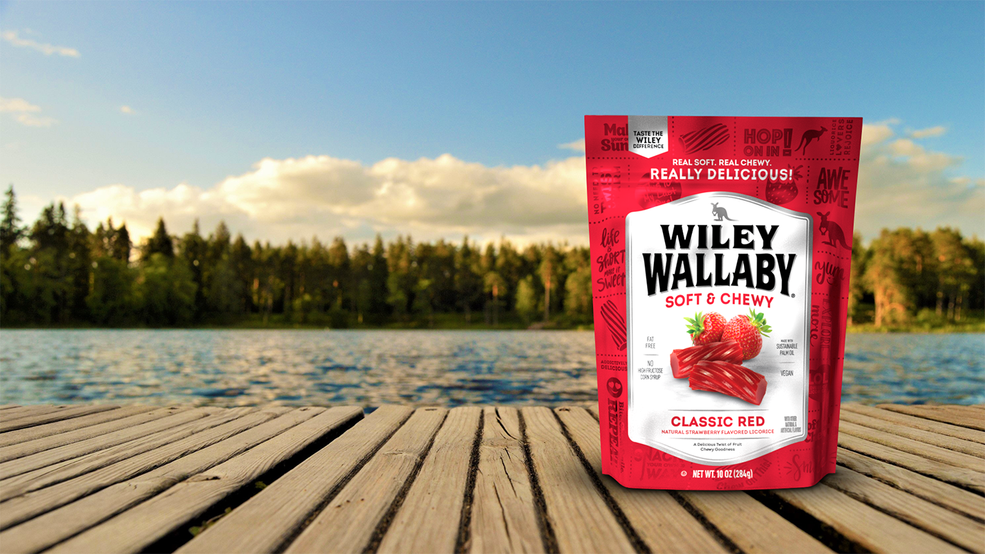 homepage_slide1 Wiley Wallaby, Explore More scene: bag of Classic Red licorice on dock with lake and trees and background